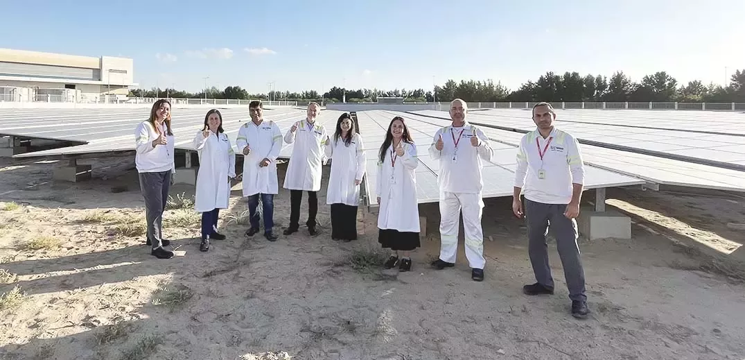 group of workers with solar panels behind