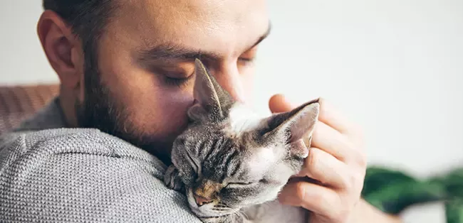man with cat snuggle moment