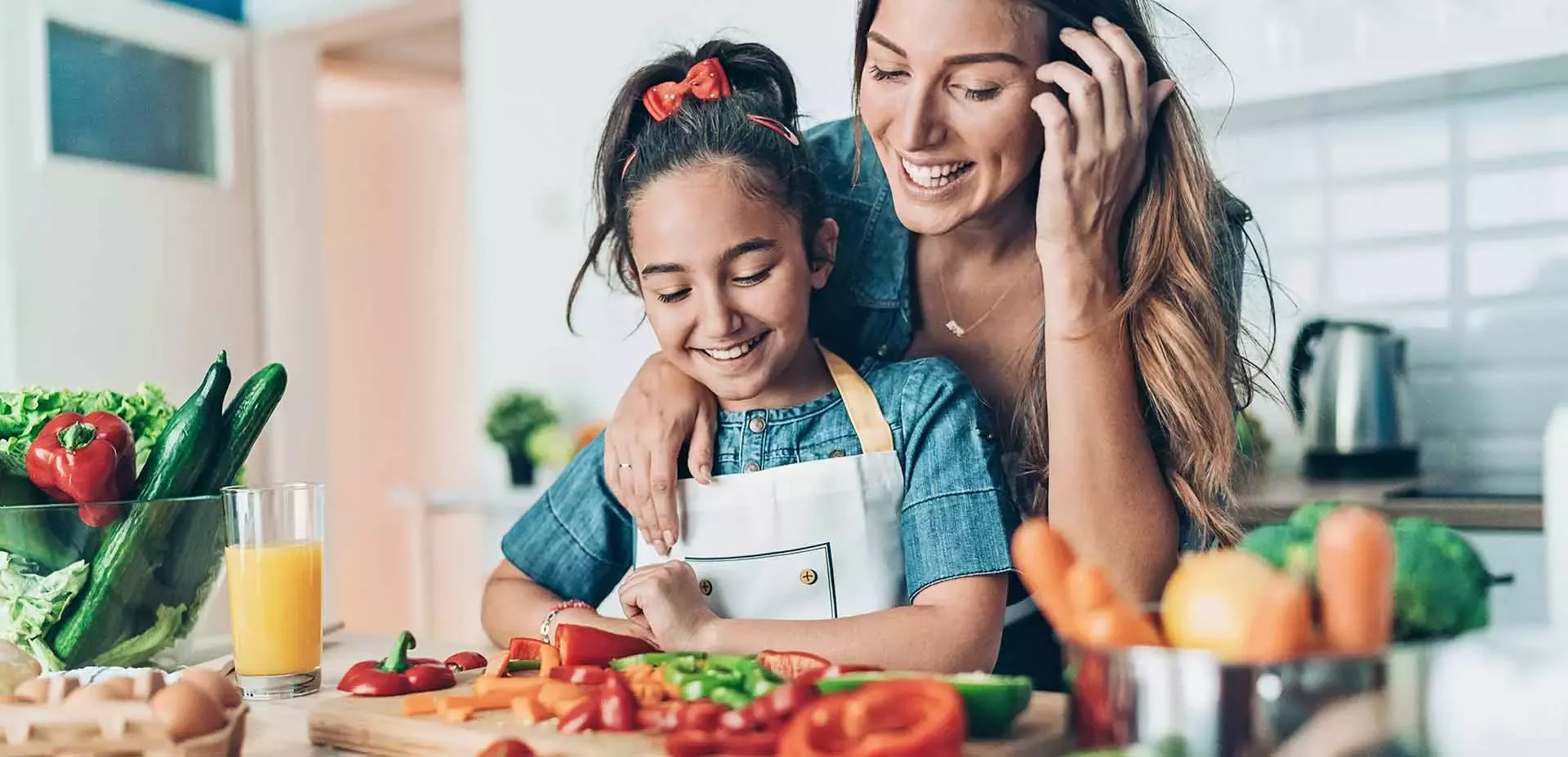 Mom and daughter cooking veggies in the kitchen
