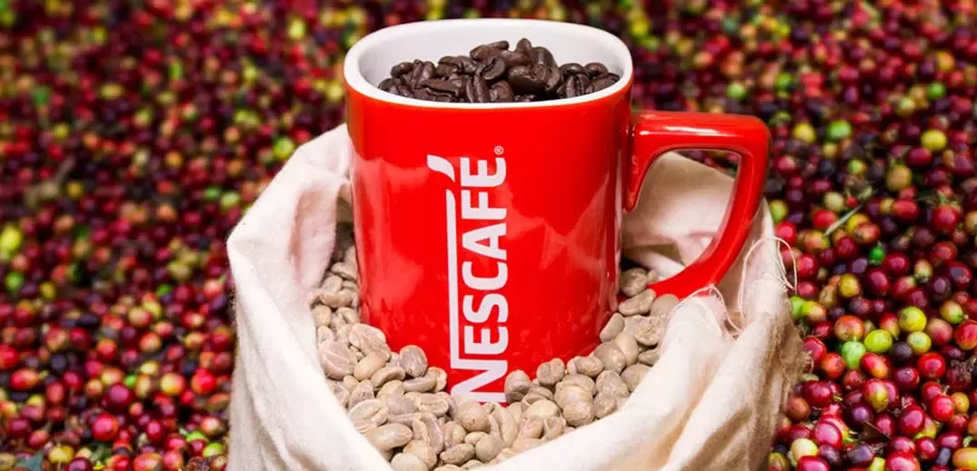 Nescafé cup on coffee beans