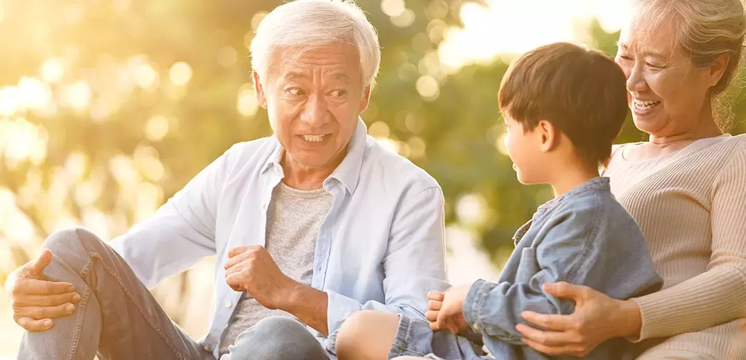 Grandparents playing with grandson outside